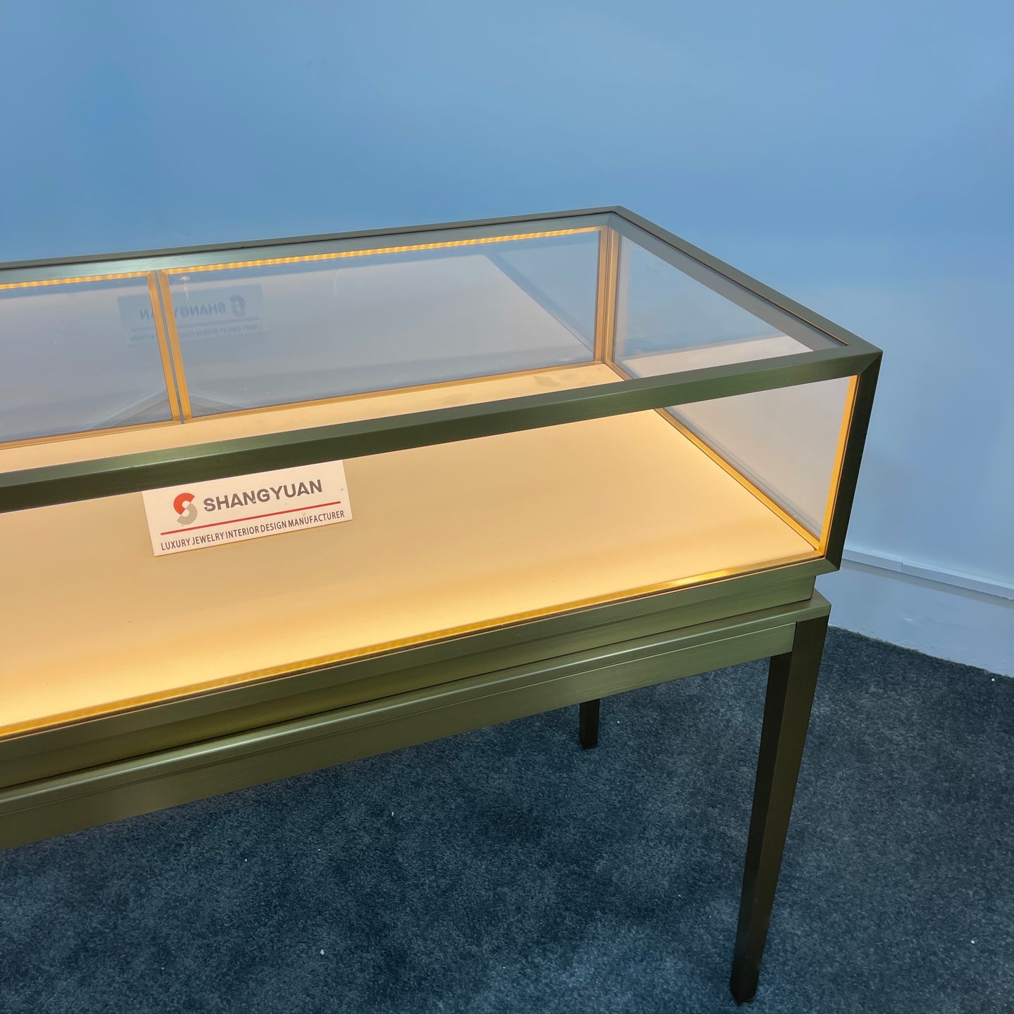 Gold brushed stainless steel jewelry display case with tempered glass top and cream velvet interior for retail store